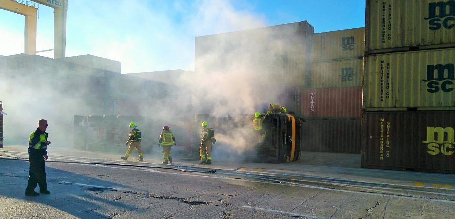 Un camión tráiler vuelca y se incendia en el Puerto de Valencia