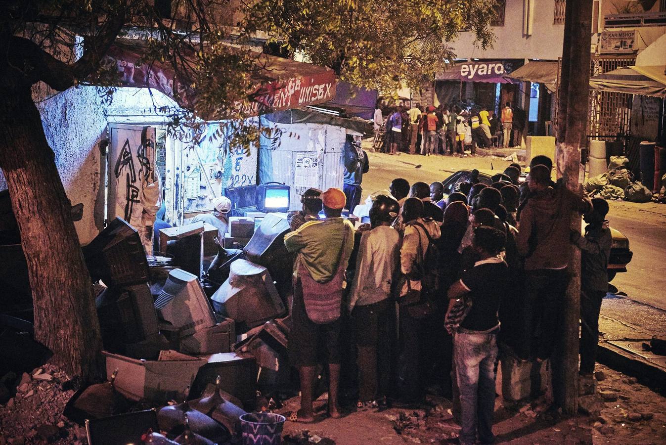 Una de las fotografías de Christian Bobst galardonadas con el segundo premio de Stories (Historias), en la categoría de deportes. La imagen muestra a un grupo de personas mientras sigue un combate de lucha en un televisor en medio de una calle de Dakar, Senegal, el 4 de abril de 2015.