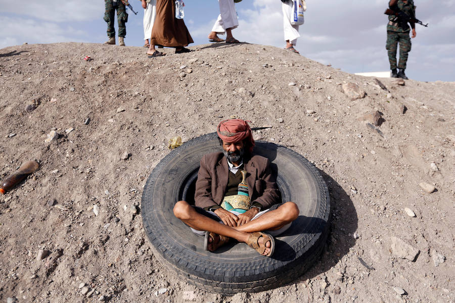 Un miembro de la tribu leal al movimiento Houthi, dentro de un neumático usado mientras observa una manifestación contra la intervención de EE.UU. en Yemen.