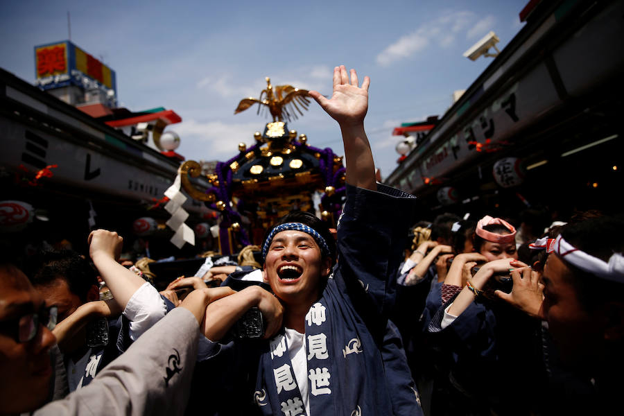 La gente lleva un santuario portátil cerca del templo de Senso-Ji durante el festival Sanja, en el distrito de Asakusa en Tokio (Japón).