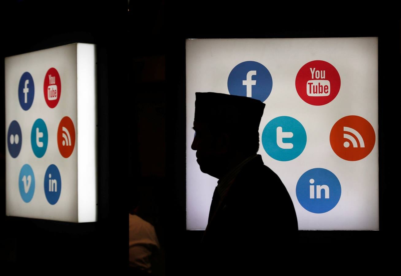 Un delegado del 41.º encuentro del Banco Islámico de Desarrollo, frente a los logos de varias redes sociales, en el centro de convenciones de Yakarta (Indonesia).