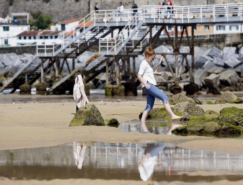 Una joven pasea por la playa de La Concha de San Sebastián