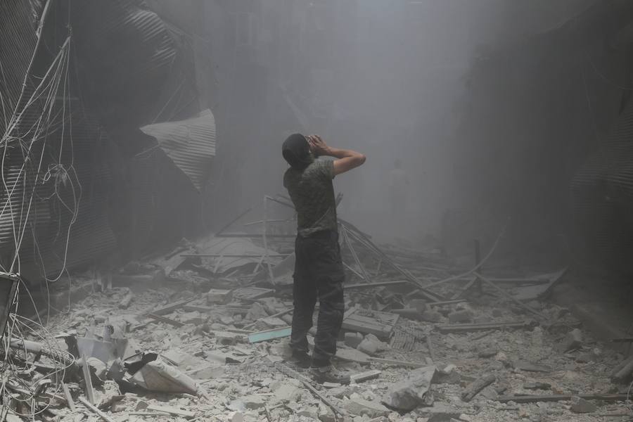 Un hombre sirio reacciona después de un ataque aéreo en la zona controlada por los rebeldes de Bustan al- Qasr.