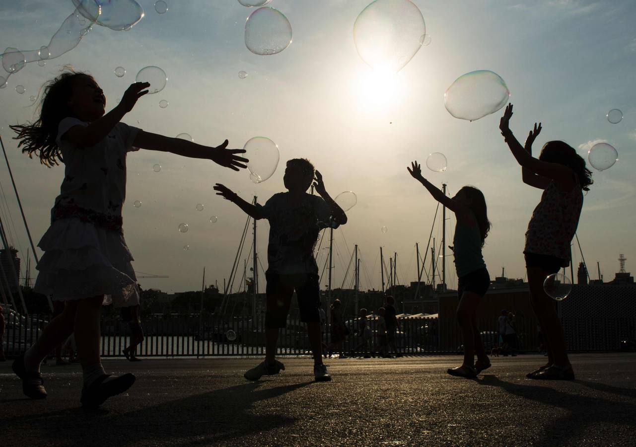 Niños jugando con pompas de jabón en Barcelona. / AFP PHOTO / JOSEP LAGO