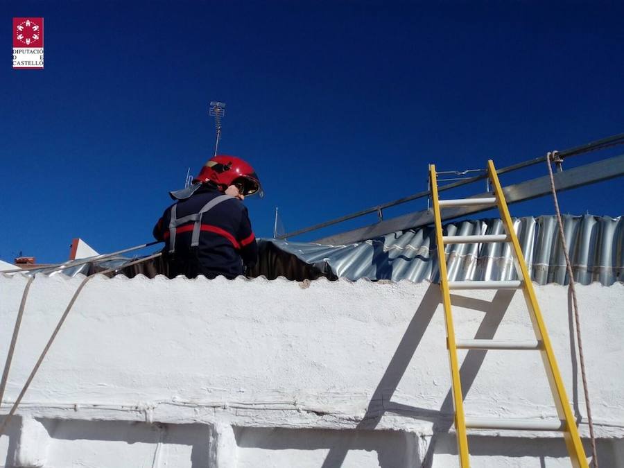 Bomberos trabajando para reitrar un techo desplazado por el viento.