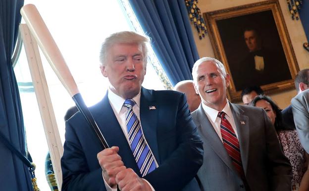 Donald Trump sostiene un bate de béisbol en un evento.
