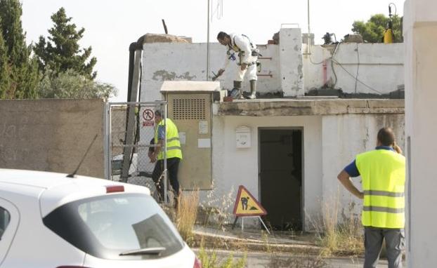 Operarios durante las labores de limpieza del depósito, ayer.