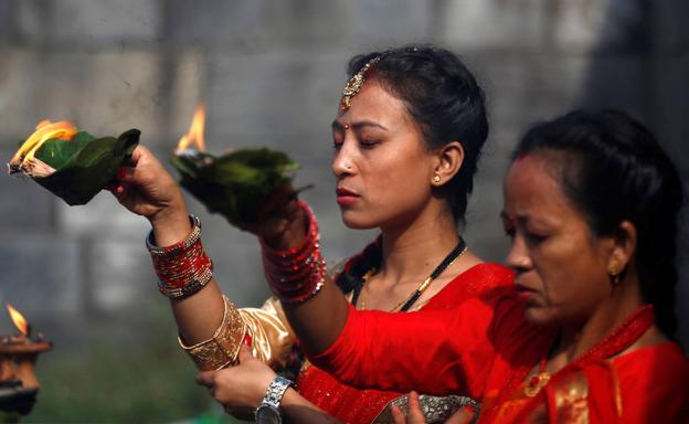 Mujeres cantan y bailan en las premisas del templo de Pashupatinath durante el festival de Teej en Katmandu, Nepal. 