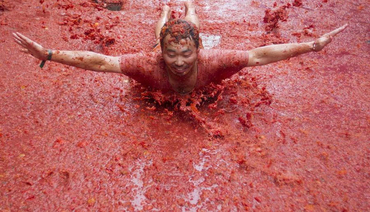 Una turista vuela en el ¨río¨ de tomates.