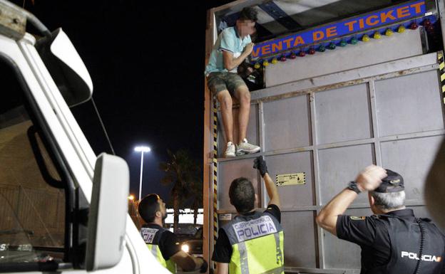 Miembros de la Policía desalojan a un menor de una atraccíon.