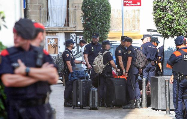 Efectivos policiales abandonando ayer el hotel Gaudí de Reus, en el que han sido hostigados durante días. 