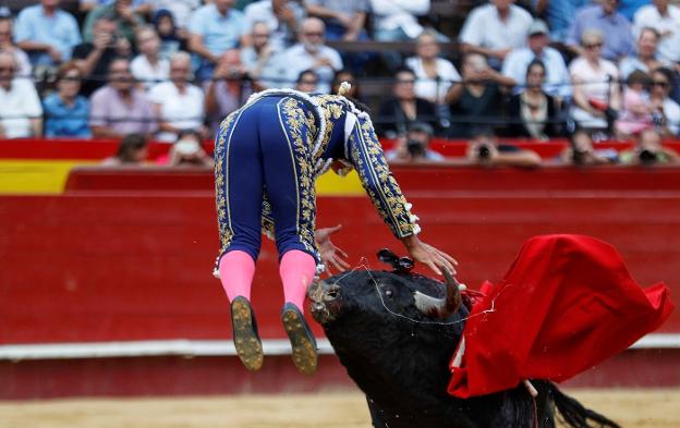 El novillero venezolano Jesús Enrique Colombo es cogido por su segundo toro. 