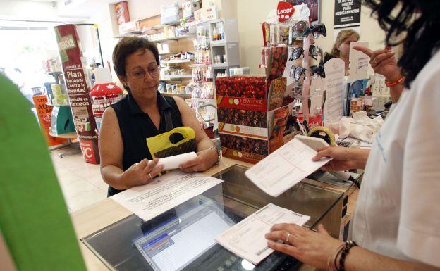 Paciente siendo atentido en una farmacia valenciana.