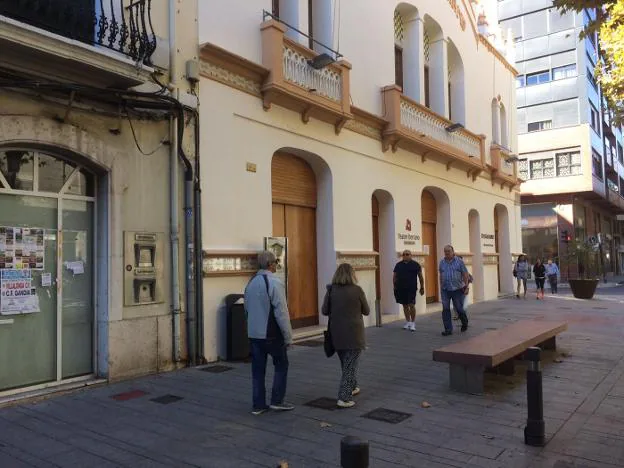 Varios vecinos de Gandia caminan ayer ante el Teatre Serrano de Gandia. 