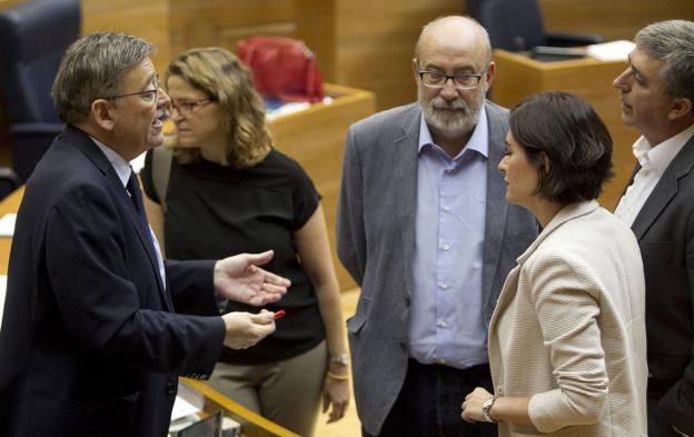 El presidente de la Generalitat, Ximo Puig, durante una charla con varios consellers en Les Corts. 