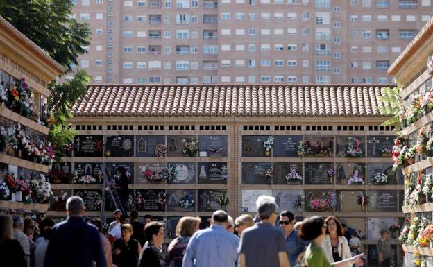 Un gran número de personas recorre uno de los cementerios de Valencia para depositar flores.