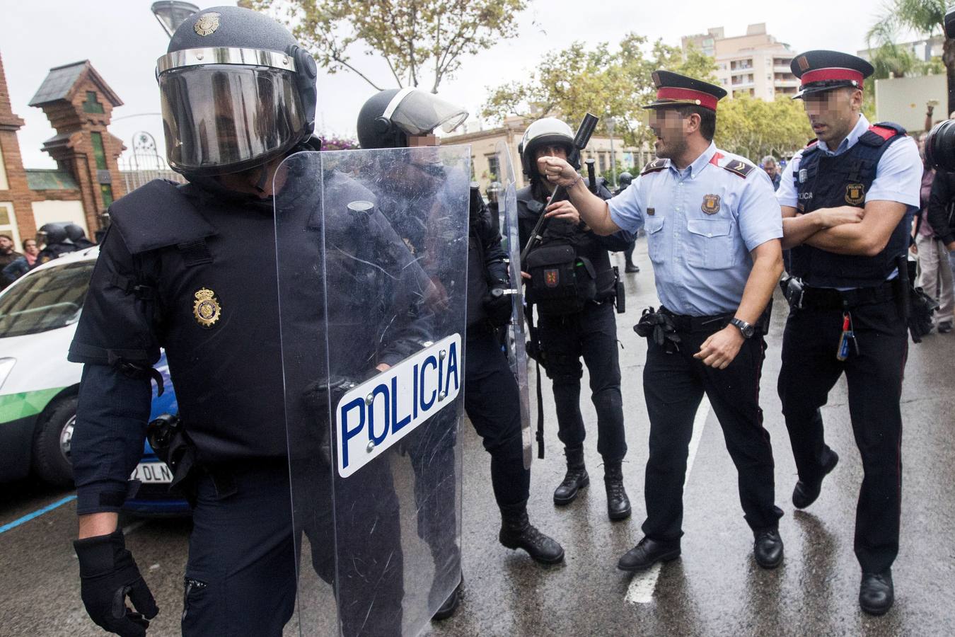 Un mosso d'esquadra se encara con un policía nacional, frente a un colegio electoral de L'Hospitalet Llobregat, Barcelona, durante la celebración del referéndum catalán 1-O, que agentes de la Policía Nacional y Guardia Civil han intentado evitar.