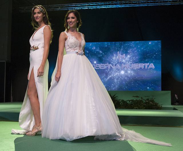 La vicepresidenta del Consell, Mónica Oltra, ha visitado la feria Fiesta y Boda y se ha probado una pieza de indumentaria valenciana en un expositor.