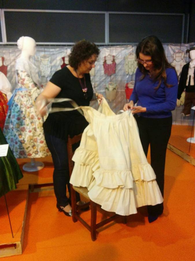 La vicepresidenta del Consell, Mónica Oltra, ha visitado la feria Fiesta y Boda y se ha probado una pieza de indumentaria valenciana en un expositor.