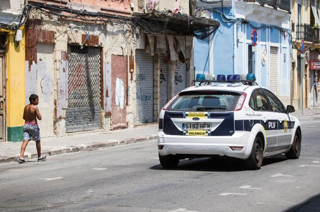 Un coche policial pasa por una calle del Cabanyal en una imagen de archivo. 
