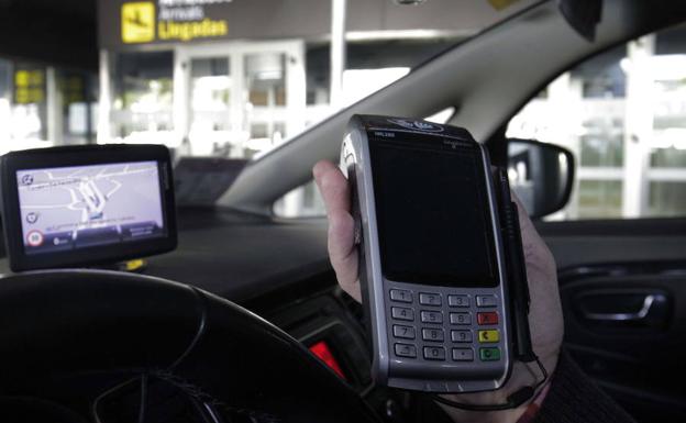 Un taxista se dispone a cobrar en Valencia. 