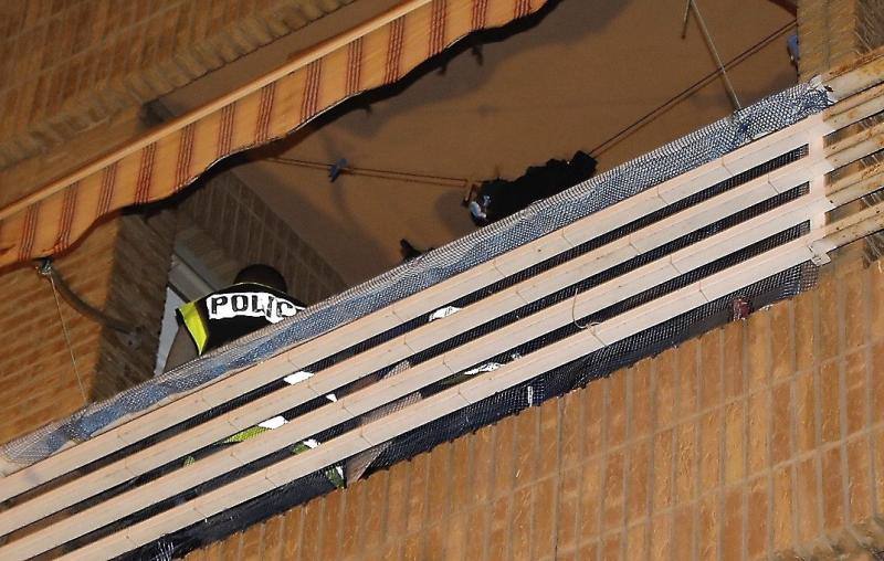 Agentes de policía en el balcón de la vivienda donde se ha cometido el asesinato.