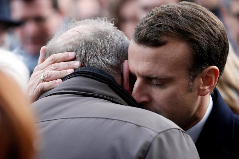 El presidente galo, Emmanuel Macron (dcha), da sus condolencias a familiares de las víctimas cerca de la sala de conciertos Bataclan, durante una ceremonia por el segundo aniversario de los atentados de París hoy, 13 de noviembre de 2017.