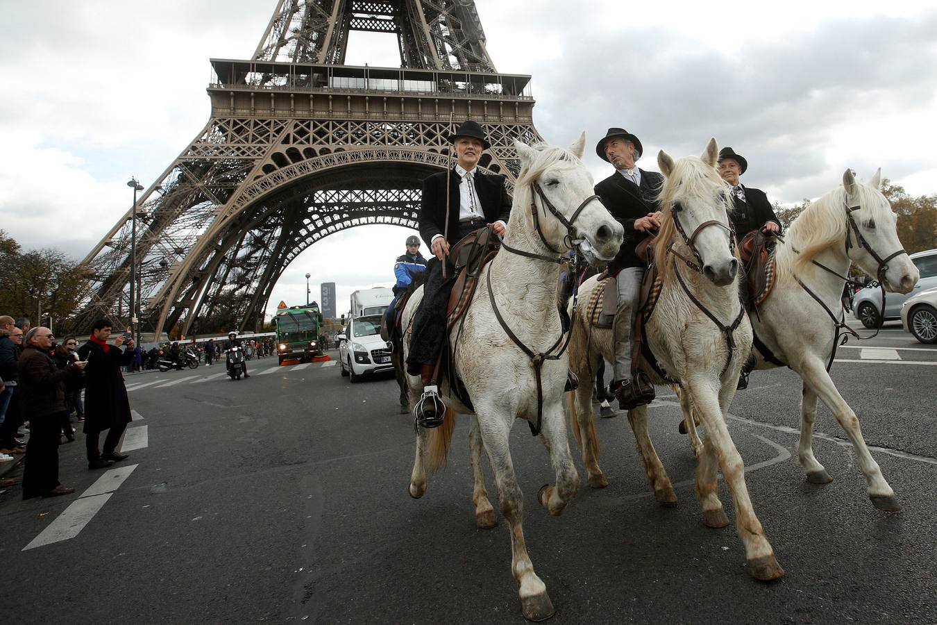 Unos jinetes montan junto a la Torre Eiffel durante un desfile ecuestre celebrado con motivo de la inauguración del Salón del Caballo de París, en Francia, 