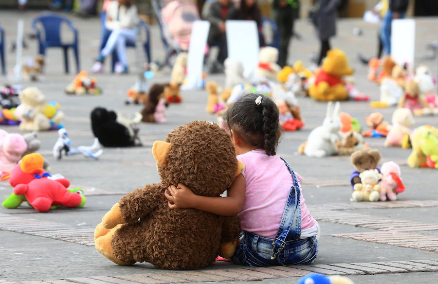 Una niña abraza un muñeco durante un "plantón de juguetes" organizado por Aldeas Infantiles SOS Colombia en contra del abuso sexual infantil, en la Plaza de Bolívar, en Bogotá (Colombia). 