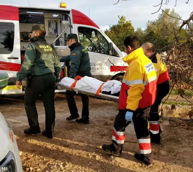 Guardias civiles y sanitarios trasladan a la anciana hasta la ambulancia. 