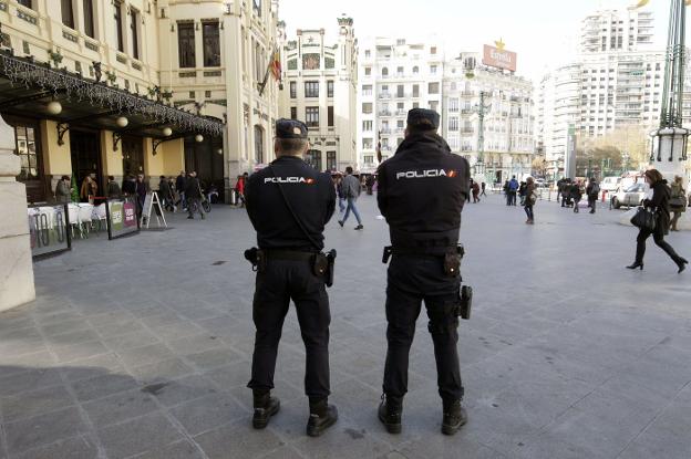 Dos policías nacionales vigilan el paso de gente en la estación del Norte. 