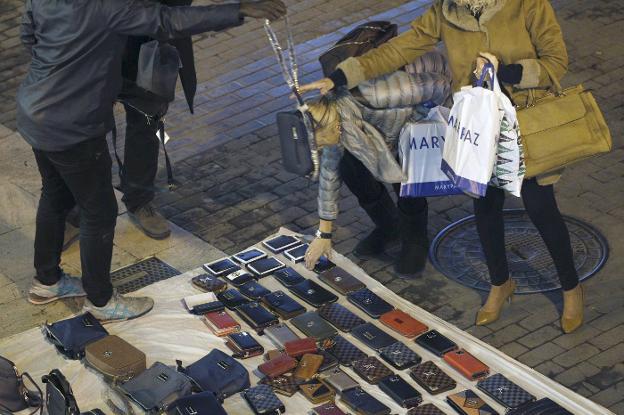 Manteros en plenas ventas en una céntrica calle de Valencia. 