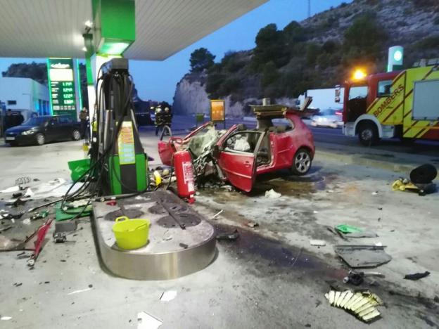 El vehículo en el que circulaban las víctimas, ayer, estrellado en la gasolinera. 