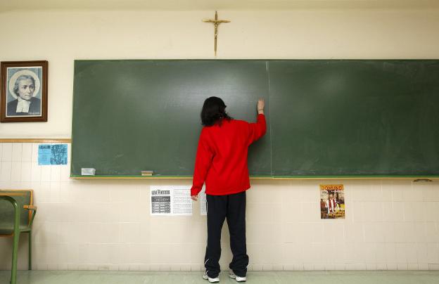 Alumna de un colegio religioso durante una clase. 