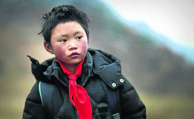 Wang, camino de la escuela ya con ropa de abrigo. Abajo, con el pelo congelado hace unos días.