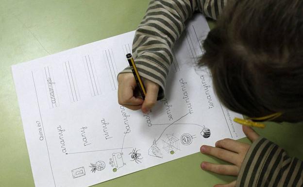 Un niño hace los deberes en su clase. 