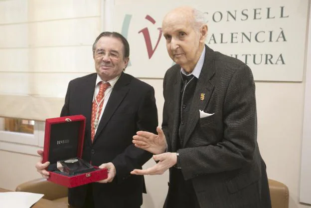 El presidente de la Real Academia, Manuel Muñoz, con la medalla que le otorga el presidente del CVC, Santiago Grisolía. 