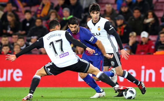 Luis Suárez se lleva la pelota ante Coquelin.