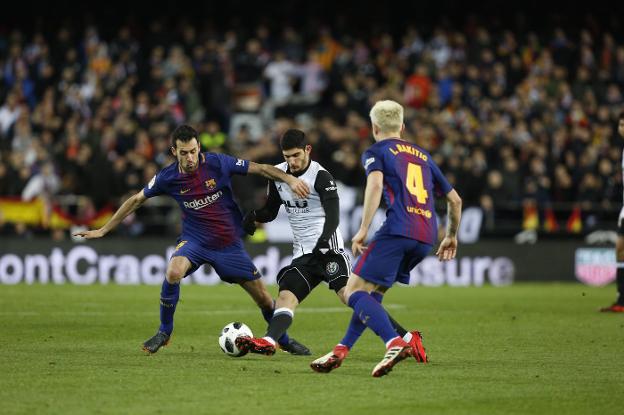 Guedes controla el balón en presencia de los barcelonistas Busquets y Rakitic. 