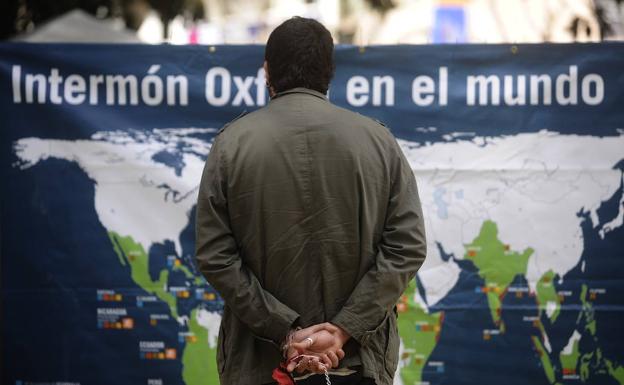 Un hombre frente a una lona de la ONG Intermón Oxfam.