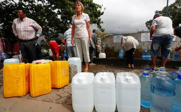 Fotografía de archivo fechada el 19 de enero de 2018 que muestra varios residentes de Ciudad del Cabo recolectan agua. 