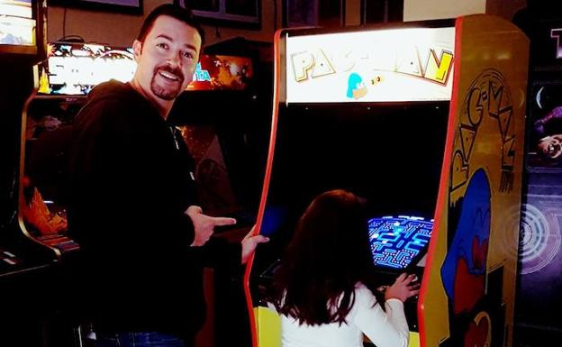 José María Litarte señala a su hija mientras juega al 'Pac Man'. 