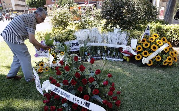 Un miembro de la Asociación de Víctimas del Metro 3 de Julio deposita un ramo de flores junto al monumento que homenajea a los 43 fallecidos. 