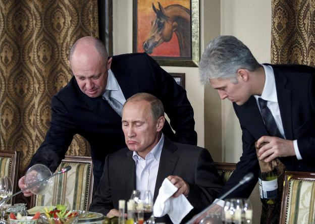 Prigozhin, a la izquierda, atiende a Putin durante una cena del mandatario con periodistas e intelectuales extranjeros. 