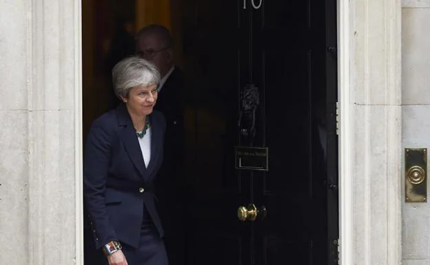 Theresa May sale del 10 de Downing Street.