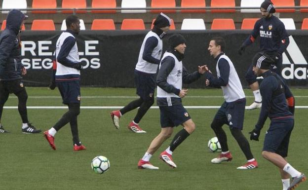 Los jugadores del Valencia se entrenaron ayer por la tarde en Paterna bajo una lluvia persistente.