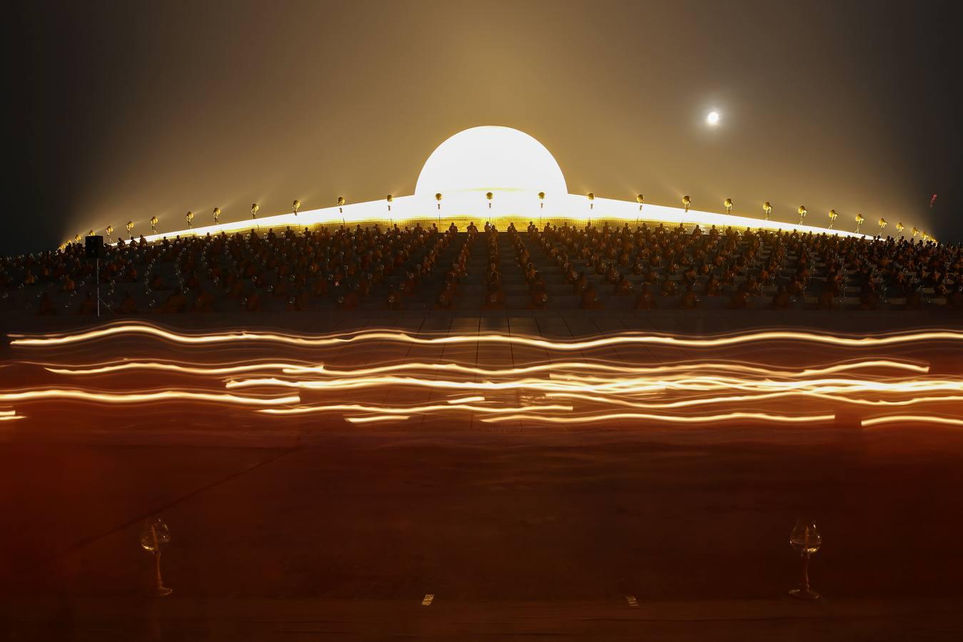 Monjes tailandeses caminan en círculo con velas en el Magha Puja, en el templo Wat Phra Dhammakaya, en la provincia Pathum Thani