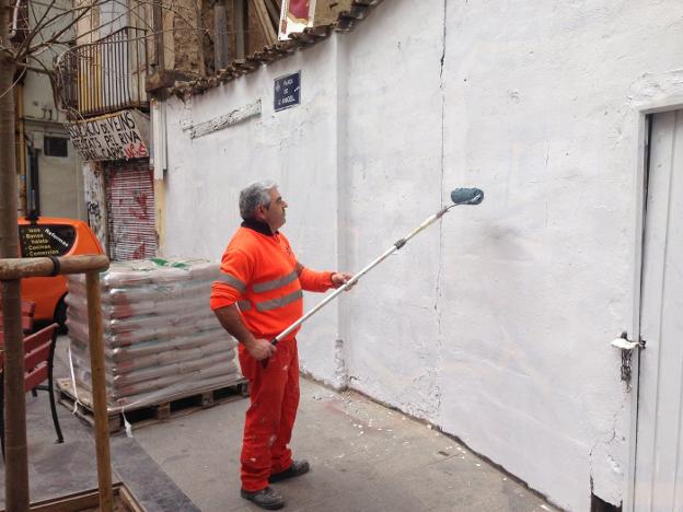 Operario de una de las brigadas de repintado de los muros, ayer en la plaza del Ángel. 