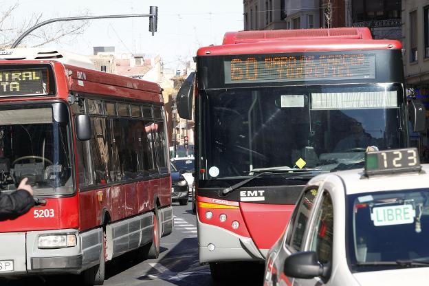 Dos autobuses de la EMT circulan por las calles de Valencia. 