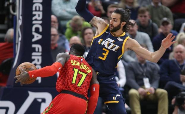 Ricky Rubio defiende a Dennis Schroder.